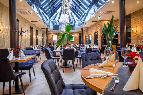 卡托维兹卡托维兹戴梦德广场酒店的餐厅设有桌椅和玻璃天花板