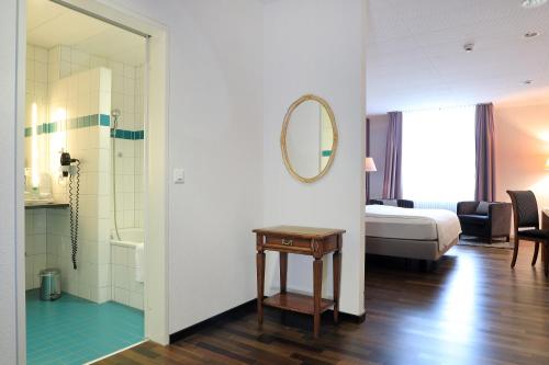 温特图尔Hotel Banana City Winterthur的一间带一张床的卧室和一间带镜子的浴室