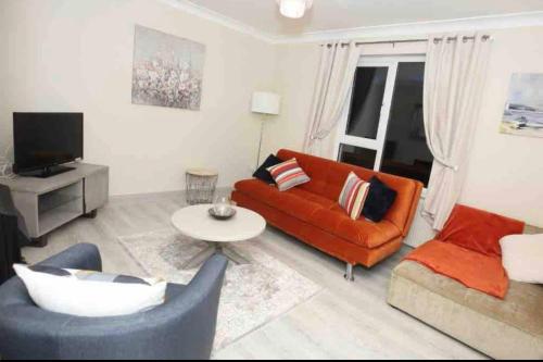 阿达拉“John Bs” 1 Bedroom Apartment in Ardara的客厅配有橙色沙发和桌子