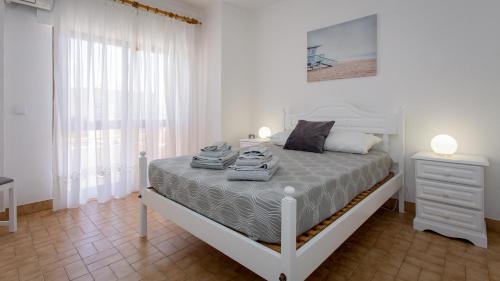 阿尔图拉Apartamento T2 na Praia da Alagoa的白色的卧室设有床和窗户