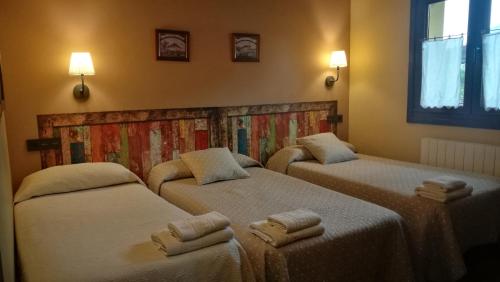 坎加斯-德奥尼斯Casas Rurales Entrecastaños的一间设有三张床的客房,备有毛巾