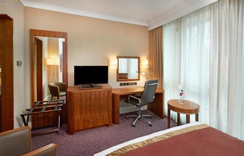 伦敦皇冠假日伦敦伊灵酒店的酒店客房配有一张床和一张书桌及一台电视