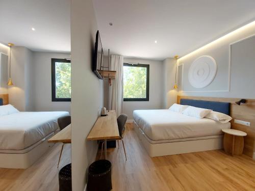 哈卡Habital Suites的酒店客房设有两张床和一张桌子。