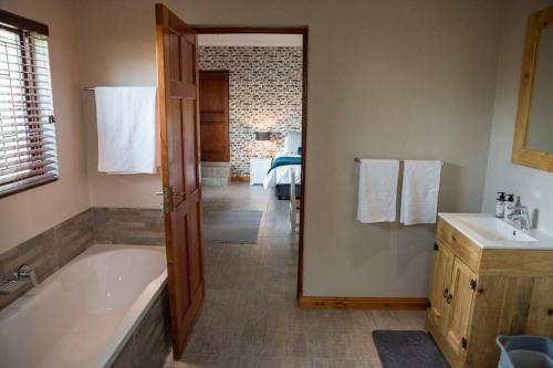 帕尔Sol Montis Guest Cottage的带浴缸和盥洗盆的浴室