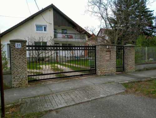 巴拉顿菲赖德Felhő Apartman的房屋前方的铁艺围栏