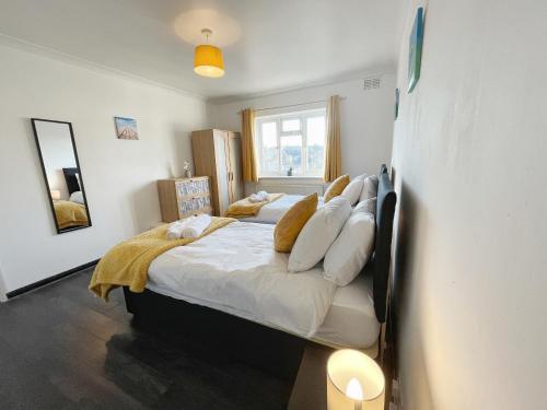 格雷夫森德3 bed duplex flat, free WIFI & Netflix, Ideal for contractors的一间卧室配有带白色床单和枕头的床。
