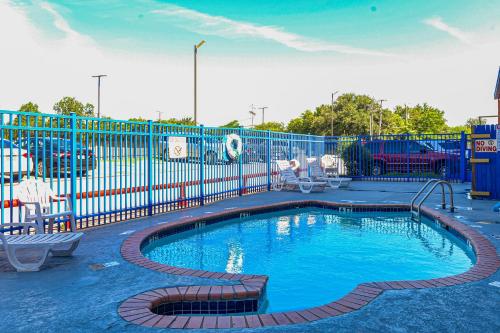 欧文OYO Hotel Irving DFW Airport South的一个带蓝色围栏的游乐场内的游泳池