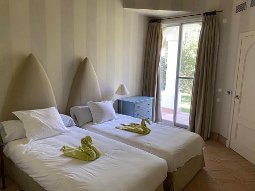 贝纳卢普-卡萨斯维耶哈斯Charming 2 bedroom villa on Fairplay Golf course的卧室内的两张床,上面有橡胶鸭