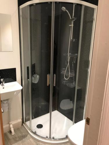 米德尔威奇金狮酒店的浴室里设有玻璃门淋浴