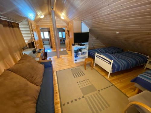 洛斯托Luoston Väärtin Kammi的一间配备有沙发、床和电视的客房