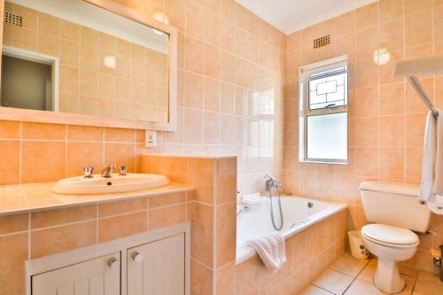 普利登堡湾Beach House Plett Lookout的浴室配有盥洗盆、卫生间和浴缸。
