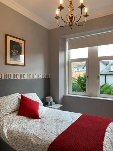 拉格斯Seaview one bedroom apartment in centre of Largs的一间卧室配有一张带红色枕头的床和窗户