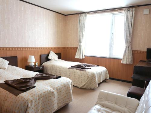 中富良野町布兰内宜吉佩提酒店的酒店客房设有两张床和窗户。