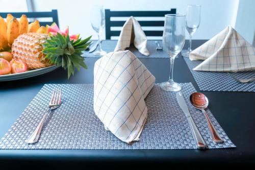 本托塔Chami Villa Bentota的一张桌子,上面有叉子和餐巾,还有一盘水果