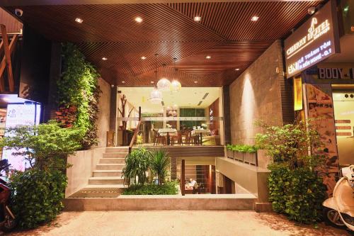 胡志明市CHERRY BOUTIQUE HOTEL的楼房的大堂,有楼梯和植物