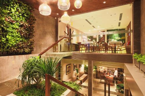 胡志明市CHERRY BOUTIQUE HOTEL的开放式的大堂设有植物和用餐区。