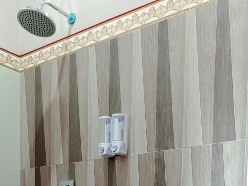 TesRedDoorz Syariah Near Danau Tes Bengkulu的带淋浴喷头的浴室
