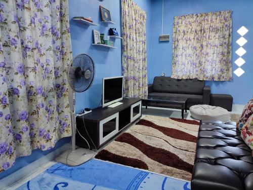 Rantau PanjangRiverview Homestay - Homestay Tepi Sungai Golok的客厅配有风扇和蓝色的墙壁。