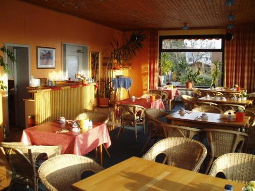 新明斯特弗里德里希酒店的餐厅设有桌椅和窗户。