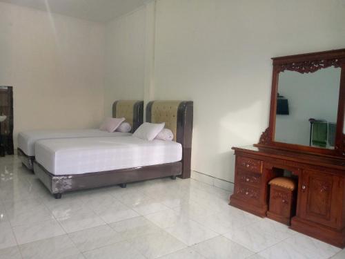 Sua DokataHomestay Hilal Meulaboh Syariah RedPartner的一间卧室配有一张床、梳妆台和镜子