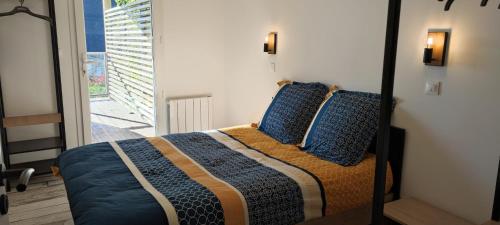 GuipavasLes terrasse du rody, vue mer .的一间卧室配有一张带蓝色枕头的床