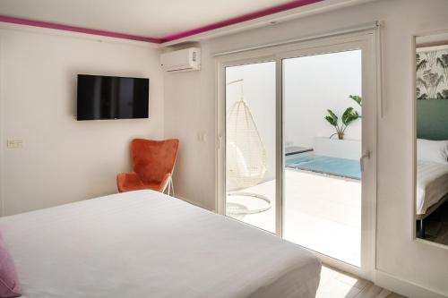 卡门港Areca by AGM Resorts的一间卧室设有一张床和一个滑动玻璃门