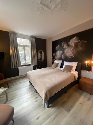蒙绍Villa Burgau B&B的卧室配有一张大床,墙上挂有绘画作品