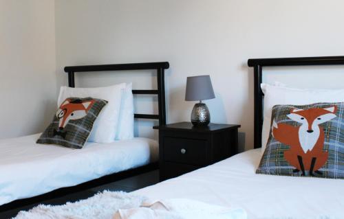 阿宾登Abingdon - Private Flat with Garden & Parking 06的一间卧室配有两张床和床头灯。