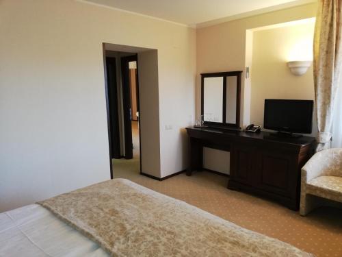 波亚纳布拉索夫Hotel ALPIN - apartament 704的一间卧室配有一张床和一张书桌及电视