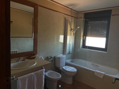 纳瓦雷东达德格雷多斯Hotel Garabatos的浴室配有盥洗盆、卫生间和浴缸。