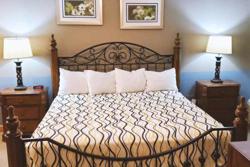 麦库克Coratel Inn & Suites by Jasper McCook的一间卧室配有一张带2个床头柜的大床