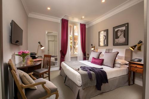 罗马Condotti Boutique Hotel的一间卧室配有一张特大号床、一张桌子和椅子