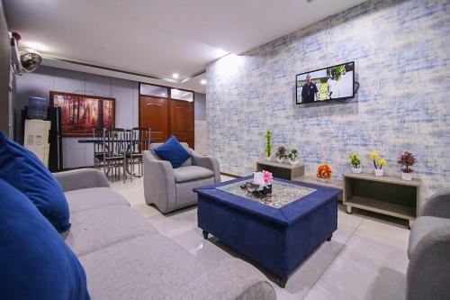 拉合尔Two Bedrooms Apartment Near DHA & Airport的带沙发的客厅和砖墙上的电视