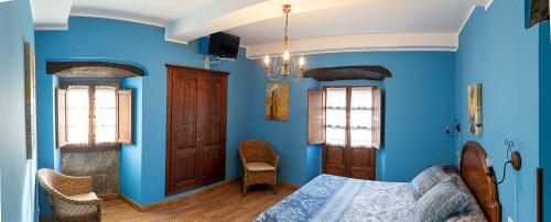 AvínLa Corrolada的一间蓝色卧室,配有床和2个窗户