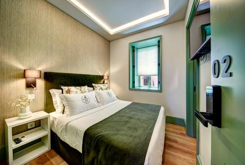 辛特拉Sintra Green Chalet Bed & Breakfast的一间卧室配有一张床和一台电视