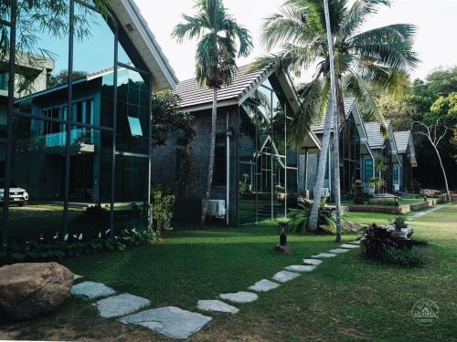 Ban Map ChalutEl Vaso Resort的前面有棕榈树的房子