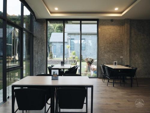 Ban Map ChalutEl Vaso Resort的用餐室配有桌椅和大窗户