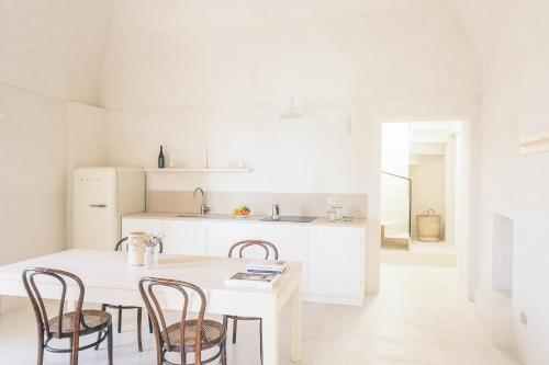 维耶斯泰Casa Pinta Rooms的白色的厨房配有桌椅