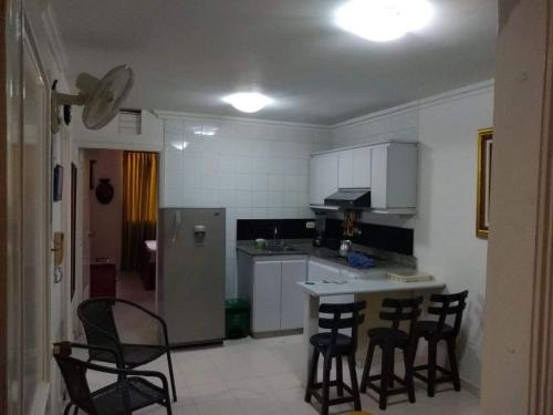 圣玛尔塔Acogedor apartamento a 15 metros del mar的厨房配有桌椅和冰箱