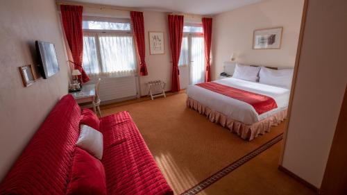 日内瓦霍勒格斯酒店的酒店客房带一张床和两张红色的沙发