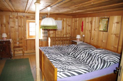 Valendas布伦度假屋的木房内的斑马印花床