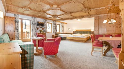 奥贝劳Landhotel Tirolerhof - Mai bis Mitte Juni kein Saunabetrieb的客厅配有床和桌椅