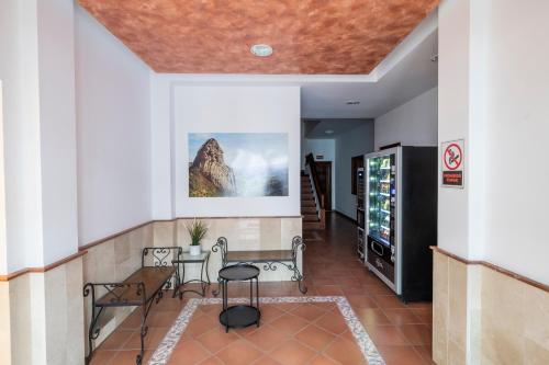 戈梅拉岛圣塞瓦斯蒂安Hotel Apartamentos Villa Gomera的大楼内带桌椅的走廊