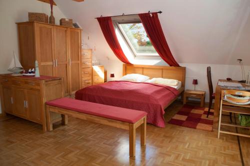 基尔吉斯私人出租酒店的一间卧室配有一张带红色毯子的床和窗户。