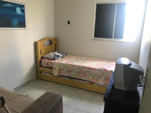 阿拉卡茹Mar Azul Condomínio的一间带床和电视的小卧室