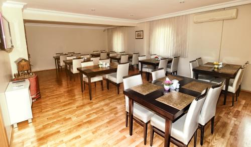 吉雷松茨尔恩蒂酒店的配有木桌和白色椅子的餐厅