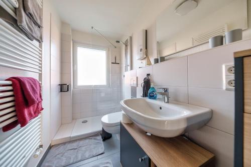 弗伦斯堡Fördepause的白色的浴室设有水槽和卫生间。