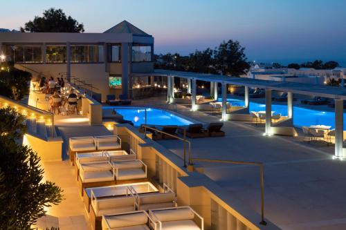 费拉马杰斯缇克酒店的一个带椅子的酒店庭院和夜间游泳池