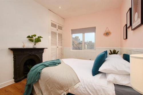 哈罗盖特Central Harrogate 2 Bedroom Apartment的卧室配有白色的床和壁炉