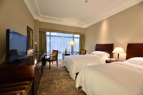 上海上海国际贵都大饭店的酒店客房设有两张床和一台平面电视。